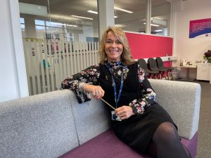 Lisa is sitting on a sofa at the Futures Hub based at Tycoch Campus